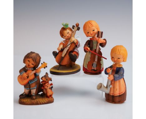 A charming group of four hand carved and painted Anri wooden figures, each depicting a cheerful child musician. One plays gui