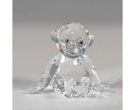 This charming Swarovski crystal figurine depicts a seated chimpanzee, part of the "African Wildlife" collection. Designed by 