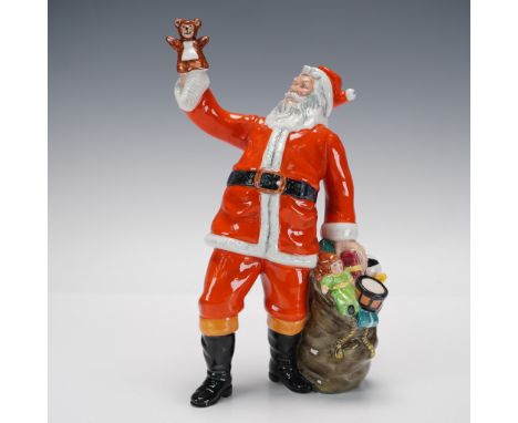 Part of Royal Doulton's Santa series, this festive piece captures Santa joyfully lifting a teddy bear in one hand while holdi