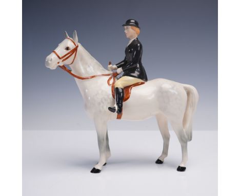 This finely modeled Beswick porcelain figurine captures a poised huntswoman astride a white horse, dressed in traditional Eng