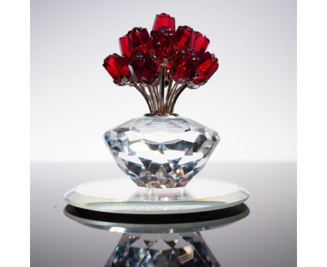 This exquisite Swarovski crystal piece features a sparkling faceted vase holding a brilliant bouquet of vibrant red crystal r