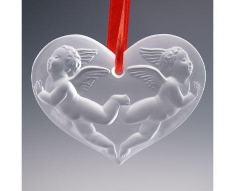 This charming heart-shaped Lalique crystal ornament from 1996 features two frosted winged cherubs in mirrored flight across a