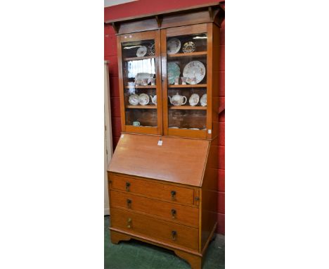 An early-mid 20th century bureau bookcase, outswept architectural cornice above a pair of glazed doors enclosing three adjust