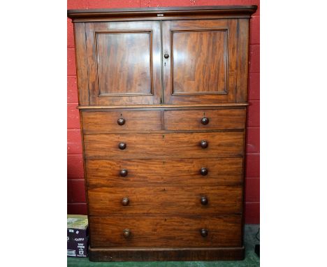 A Victorian mahogany linen press, rounded cornice above a pair of panel doors enclosing a shelf, the base with two short over