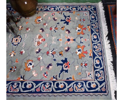 A Chinese carpet/rug, woven throughout with stylised flowers and foliage on a jade green ground, 198cm x 131cm