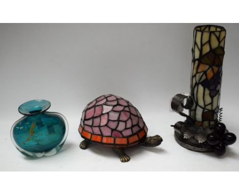 A novelty table lamp, as a tortoise, leaded glass; another, similar, as a chamber stick; a Mdina turquoise blue glass flatten