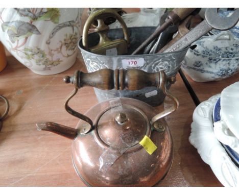 A decorative planter containing a brass door knocker and assorted tools