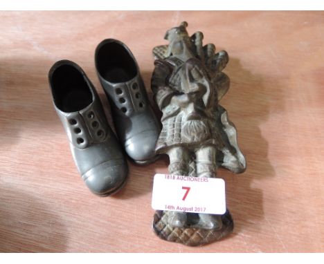 A vintage cast door knocker modelled as a piper and a pair of metal work ornamental shoes