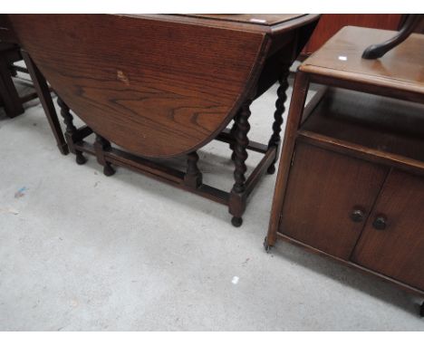 A mid 20th Century oak twist gate leg table and a similar period side cabinet/trolley 