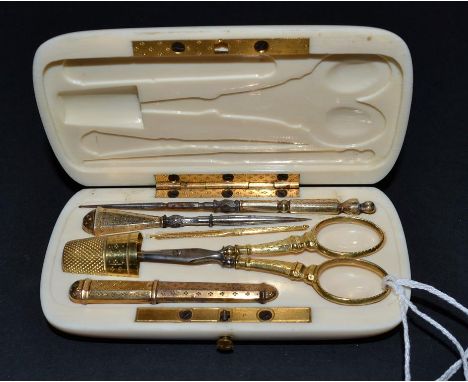 A Gilt Metal Sewing Set presented in an elegant oval ivory case, unlined but shaped to take the tools. The exterior lid is de