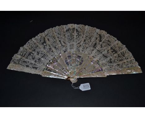 A Late 19th Century Lace Fan, the intricate monture of light pink mother-of-pearl, carved and pierced with thin sheets of mot