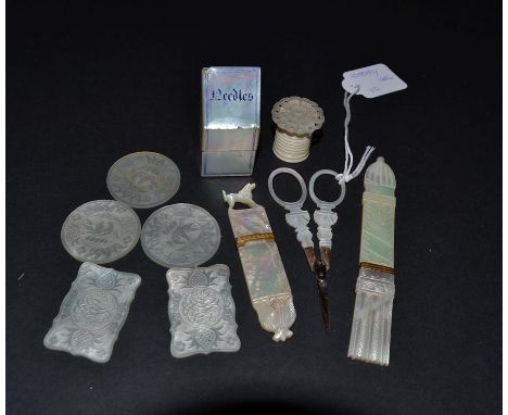 Ten Mother-of-Pearl Sewing Items, to include a slender needle holder carved with flowers, shaped lower end, and a dog perched