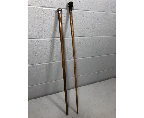 Two walking canes, one with silver top, the other with an articulated monkey head with push button to move mouth and glass ey