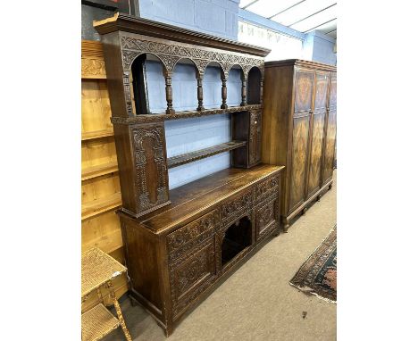 Large Victorian gothic revival heavily carved oak dresser with two shelf back, two small integral side doors over a base with