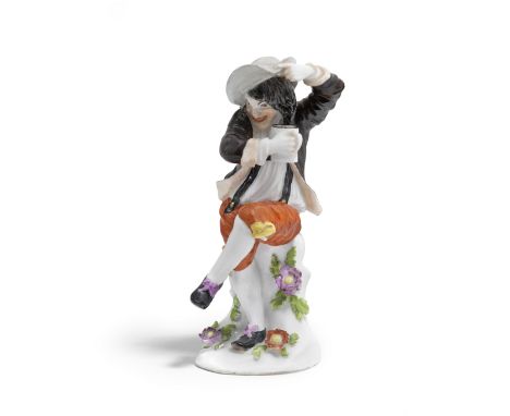 A Meissen figure of a drunken peasant, circa 1745Modelled by J.J. Kaendler, wearing a grey hat, brown jacket and iron-red bre