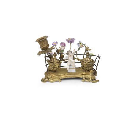 A gilt-metal and Samson porcelain ink stand, 19th centuryThe scrollwork base applied with a Samson porcelain winged putto bet