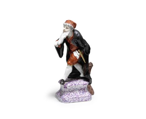 A Höchst Commedia dell'Arte figure of Pantalone, circa 1755Modelled by J.C.L. von Lücke, wearing a fur-lined red hat, black l