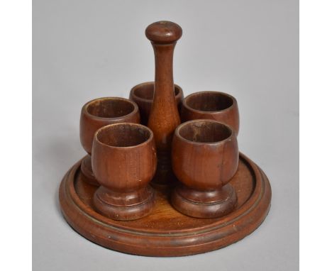 A Treen Egg Cup Stand having Centre Stem of Vase Form Adjoining to Circular Base Housing Six Turned Egg Cups. 14cms High 