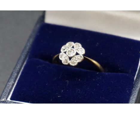 A diamond set yellow metal daisy ring, size M-M 1/2. 