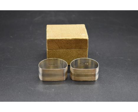 A pair of cased engine turned silver napkin rings, by J G Ltd, Birmingham 1953, 50g. 