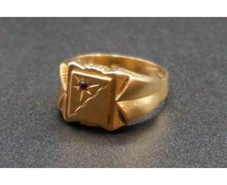 A yellow metal signet ring, stamped 750, set one small garnet, size S, gross weight 5g. 