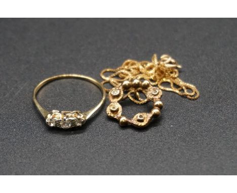 A yellow metal diamond three stone ring, size Q 1/2; together with a 9ct gold pendant set white stones on a fine 9ct gold cha