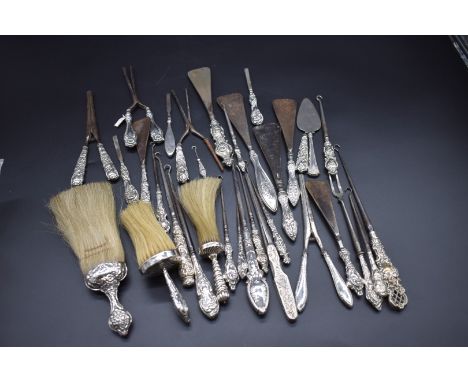 A large quantity of silver handled items, to include: shoehorns; button hooks; glove stretchers; brushes; etc. (34) 