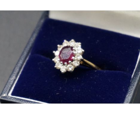 A yellow metal ruby and diamond cluster ring, stamped 18ct plat, size L 1/2. 