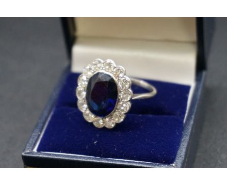 A 1930s sapphire and diamond cluster ring, stamped Plat, set central collet set oval faceted sapphire surrounded by fourteen 