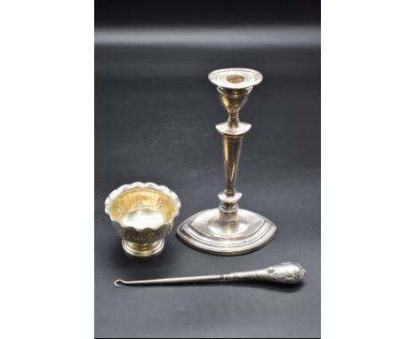 A silver candlestick, (s.d); together with a silver handled steel button hook; and a Burmese metal sugar bowl. (3) 