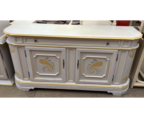 A modern cream and yellow painted side cabinet with three drawers and two cupboards on bracket feet