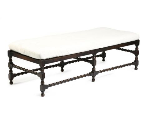 An early 20th century stained wood long stool, with a cane seat, on baluster and block supports, united by spiral twist stret
