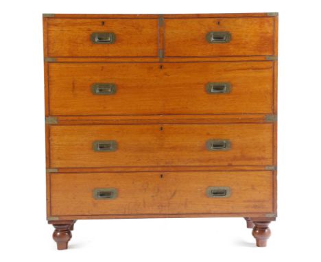 A large late Victorian teak campaign chest, in two halves, with brass mounts, with two short and three long drawers, the top 