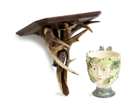 A pottery bowl, decorated with two green man faces, with oak leaves and insects, together with a Victorian oak and antler wal