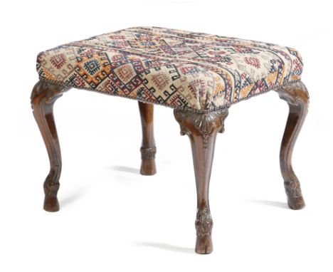 A Portuguese walnut stool in 18th century style, with a kilim style upholstered seat, on leaf and rocaille cabriole legs and 