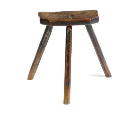 A 19th century elm dairy stool, on tripod supports, 52.7cm high, 58.5cm wide. Provenance: The collection of the late Geoffrey