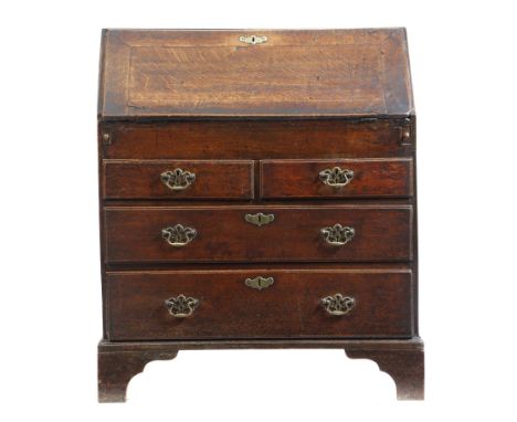 An early 18th century oak bureau, the interior with an arrangement of pigeon holes, drawers and a secret pilaster compartment