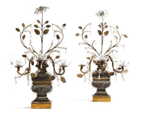 A pair of French gilt metal and glass candelabra attributed to Maison Baguès, in the form of an urn issuing leaves and a flow