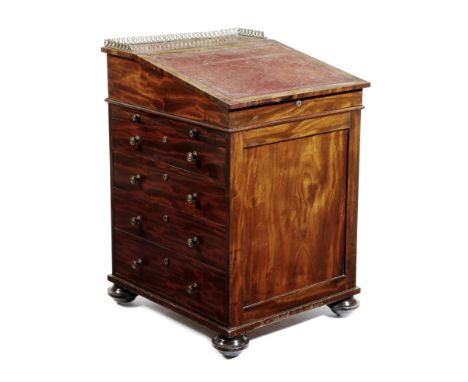 A George IV mahogany Davenport in the manner of Gillows, the sliding top with a brass gallery, above a hinged leather lined w