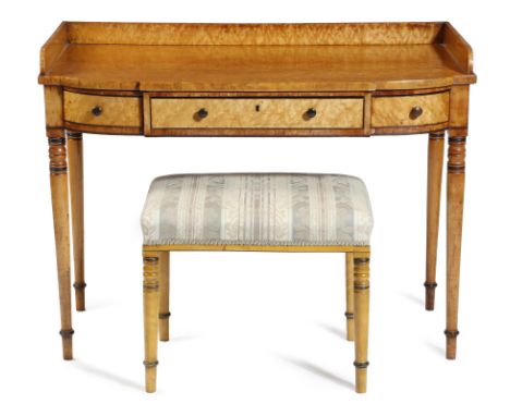 A Regency bird's eye maple dressing table, with ebonised decoration, with a three-quarter gallery, above three frieze drawers