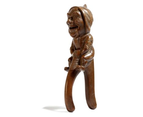 A late 19th century Swiss Black Forest type carved walnut figural nut cracker, in the form of a laughing gnome, 26cm high.Cli