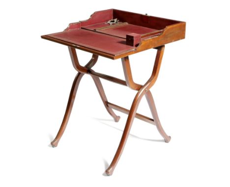A Victorian mahogany campaign folding writing desk, with a gilt tooled maroon leather interior, with a pair of silvered paper