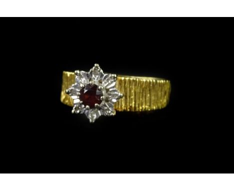 A ruby and diamond cluster ring, with central ruby surrounded by eight tiny illusion set diamonds, on bark effect ring band, 