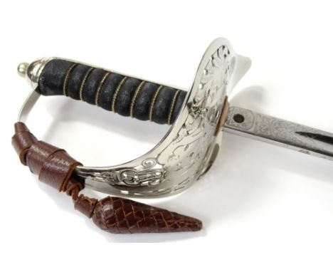 A George V dress sword, with an engraved blade, shark skin handle and pierced guard, housed within a brown leather scabbard w