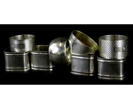 A collection of silver and silver plated napkin rings, the three silver examples, each with engine turn decoration, 2¾oz.