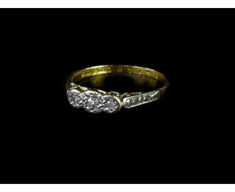 An 18ct gold and platinum dress ring, with three illusion set tiny diamonds, in platinum setting on raised ring head with pie