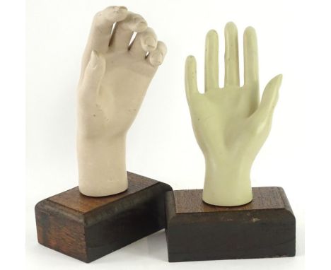 A pair of late 20thC mannequin hands, each mounted on a wooden block to convert to a ring stand, the largest 27cm H.