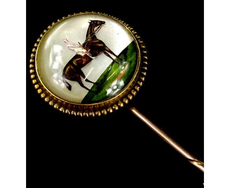 An Essex crystal stick pin, with circular pin head depicting a figure on horseback, 2cm dia, with beaded border, yellow metal