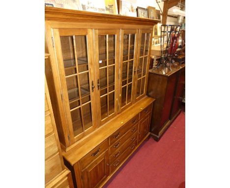 A contemporary American cherry wood dresser, having four glazed upper doors, shelved interior, over base fitted with six draw