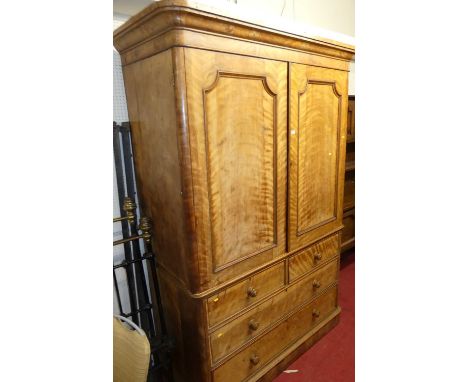 An early Victorian satin wood round cornered linen press, the twin panelled upper doors enclosing four interior linen slides,